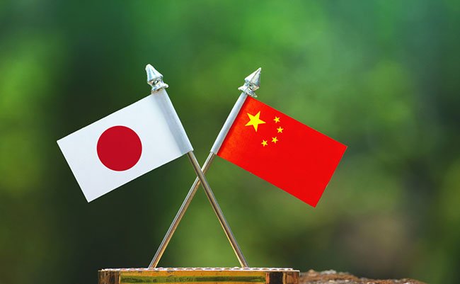 China and Japan small flag with blur green background