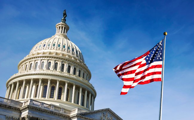American,Flag,Waving,With,The,Capitol,Hill,In,The,Background