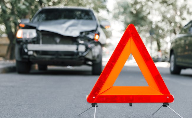 Red emergency stop triangle sign on road in car accident scene. Broken SUV car on road at traffic accident. Car crash traffic accident on city road after collision. Long web banner