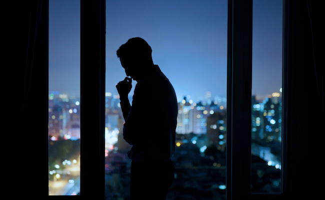 Worried,Asian,Young,Businessman,Is,Standing,Near,Windows,While,Working