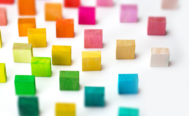 Spectrum of multi colored wooden blocks standing, on white background.  Background image or cover for something creative or diverse.