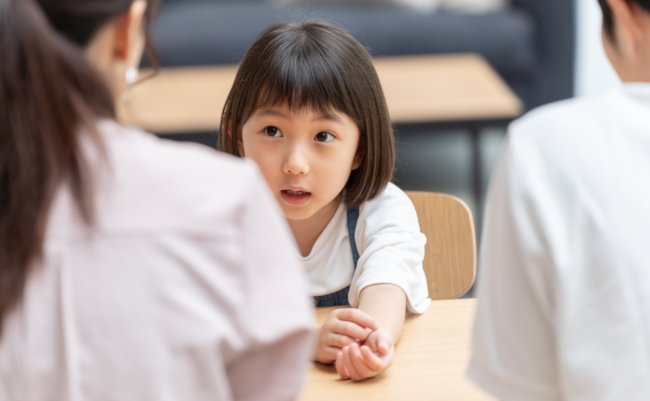 A,Little,Asian,Girl,Talking,To,Her,Parents