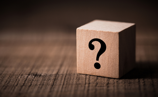 Question mark block stand on wooden background with copy space.