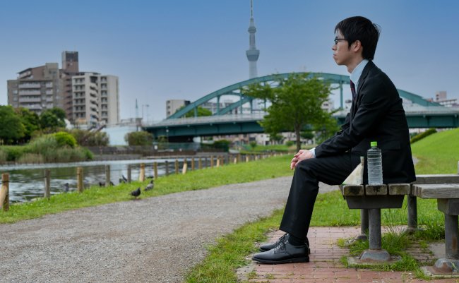 Japanese,Man,Sitting,On,A,Bench,In,A,Park,With