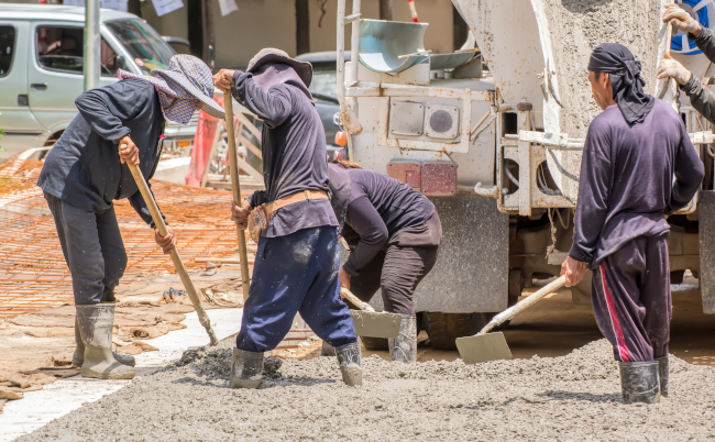 Construction,Worker,Pouring,Cement,For,Doing,The,Road.