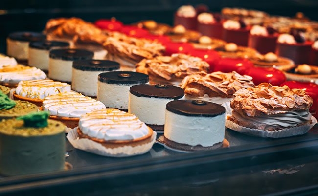 Delicious fresh cakes in the pastry shop behind the glass