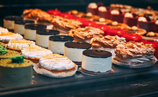 Delicious fresh cakes in the pastry shop behind the glass