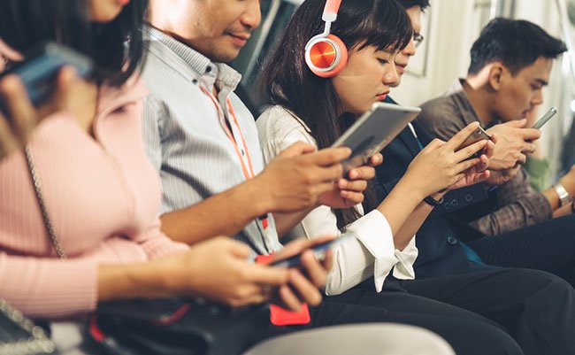Young people using mobile phone in public underground train . Urban city lifestyle and commuting in Asia concept .