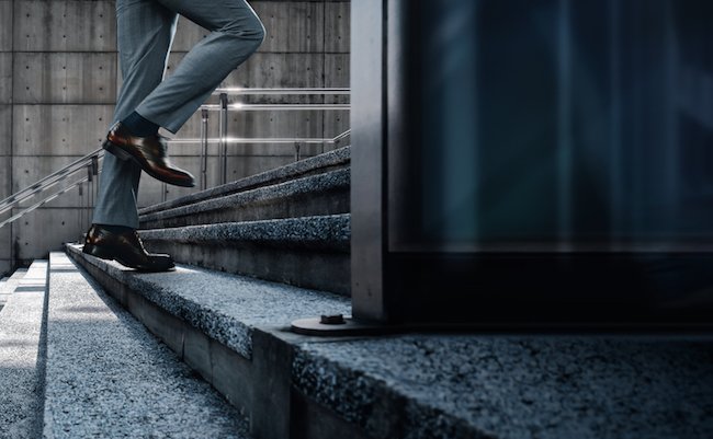 Motivation and challenging Concept. Steps Forward into a Success. Low Section of Businessman Walking Up on Staircase. City Scene