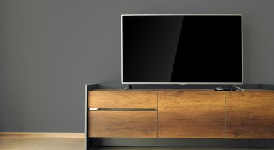 Led TV on TV stand with black wall
