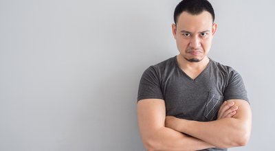 Angry and crazy asian man in black t-shirt and skinhead hair style.