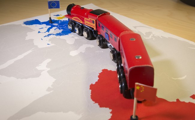 Toy train connecting Europa and China. Symbolizing the New Silk Road or one belt one road Chinese strategic investment in the 21st century. Economic project to connect EU, Central Asia and China