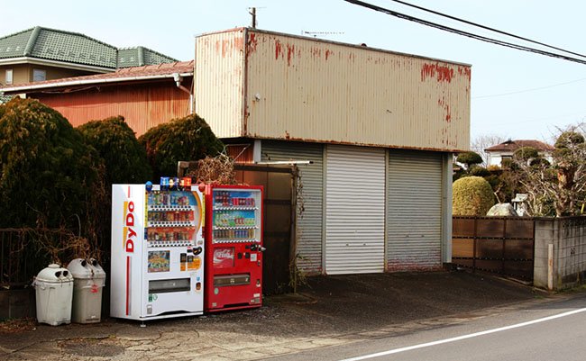 CHIBA, JAPAN - January 18, 2018: A pair of drinks vending machines next to a shuttered closed-down store on a main road in Shirako Town on the Boso Peninsula in rural Chiba Prefecture.