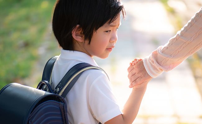 Asian child feeling sad when go to school with mother