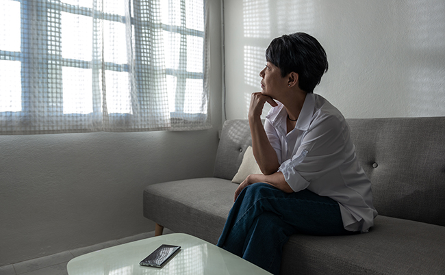 A,Senior,Gray-haired,Asian,Woman,Is,Sitting,On,A,Couch