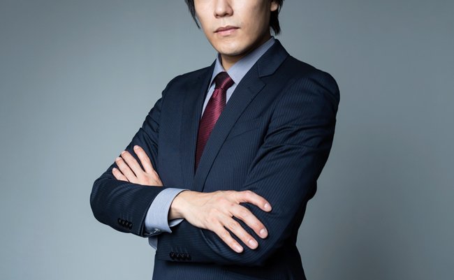 Young asian businessman folding arms.