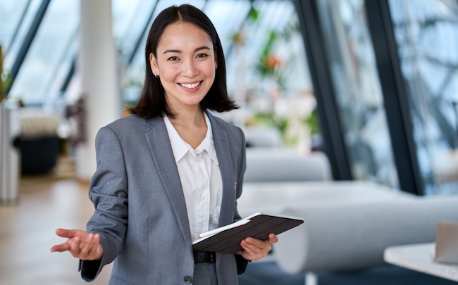 Happy,Young,Asian,Saleswoman,Looking,At,Camera,Welcoming,Client.,Smiling