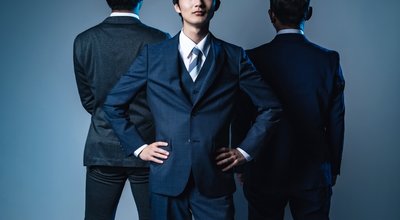 Young,Asian,Businessman,Posing,Between,Two,Bosses.