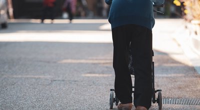 Japanese,Senior,With,A,Walking,Disability,Walking,On,Street,Pushing