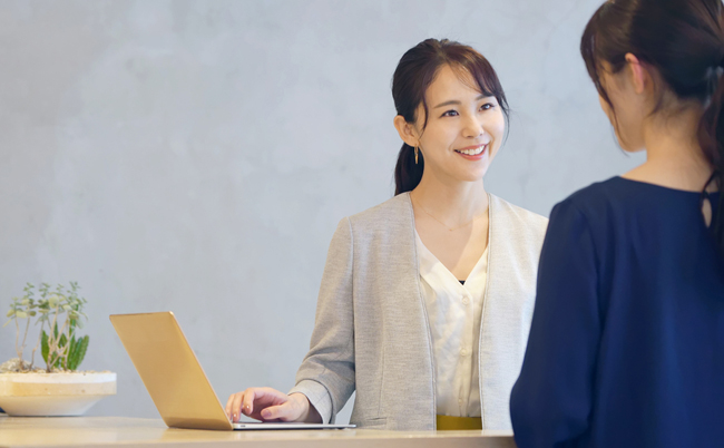 Young,Asian,Receptionist,Talking,With,Customers.,Hotel,Worker.,Store,Clerk.