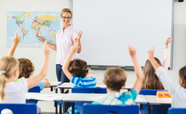 Teacher teaching kids in classroom at school