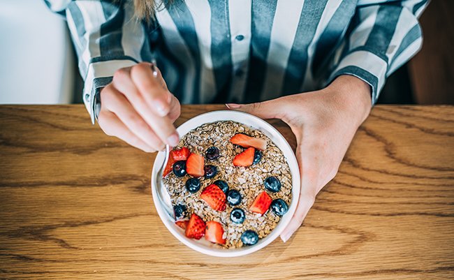 Crop,Woman,Close,Up,Eating,Oat,And,Fruits,Bowl,For