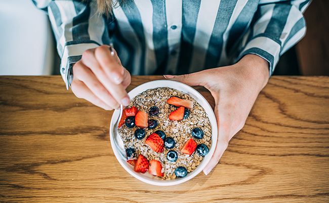 Crop,Woman,Close,Up,Eating,Oat,And,Fruits,Bowl,For