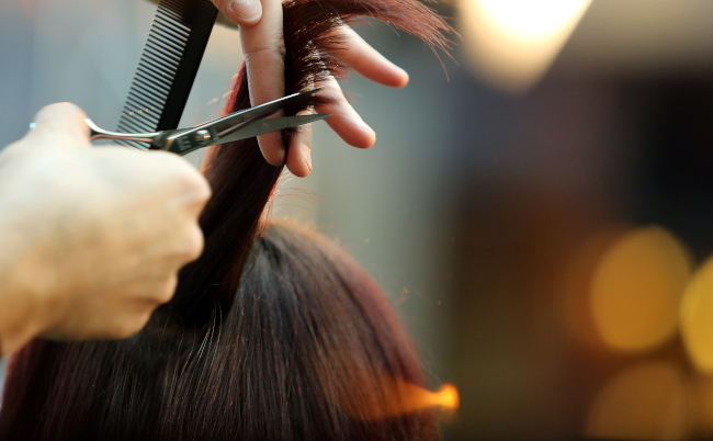 Hairdresser,Trimming,Blond,Hair,With,Scissors