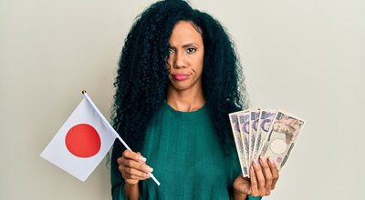 Middle,Age,African,American,Woman,Holding,Japan,Flag,And,Yen