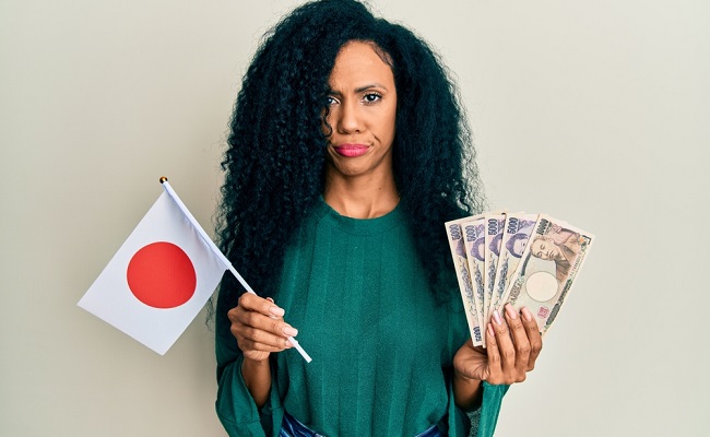 Middle,Age,African,American,Woman,Holding,Japan,Flag,And,Yen