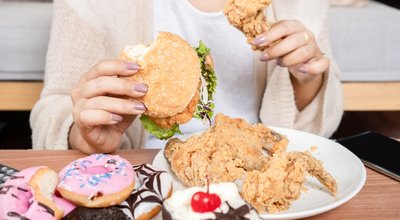 Unhealthy,Woman,Over,Eating,Fast,Food,Burgers,,Fired,Chicken,,Donuts,
