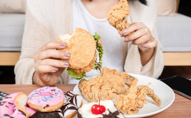 Unhealthy,Woman,Over,Eating,Fast,Food,Burgers,,Fired,Chicken,,Donuts,