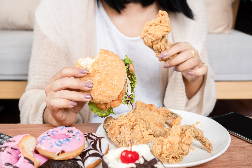 Unhealthy,Woman,Over,Eating,Fast,Food,Burgers,,Fired,Chicken,,Donuts,