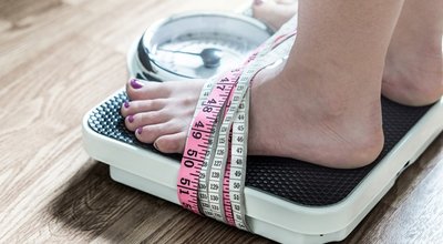 Feet,Tied,Up,With,Measuring,Tape,To,A,Weight,Scale.