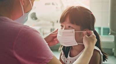 Asian parents wear masks to their children because of transmissible infectious diseases indoor in the airport