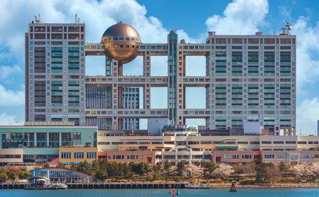 tokyo, japan - april 04 2020: Aqua City shopping centers on the island of Odaiba with the building of the Japanese television channel Fuji TV famous for its Hachitama observation area in spring.