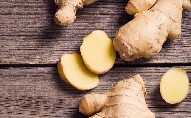 Ginger root sliced on wooden background