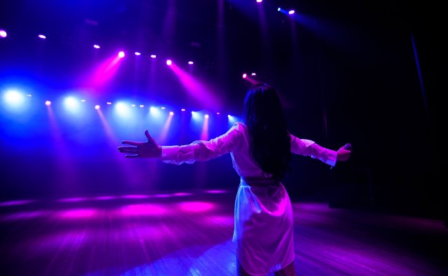 Unrecognizable,Singer,Standing,On,Stage,At,Microphone,,Back,View,,Neon