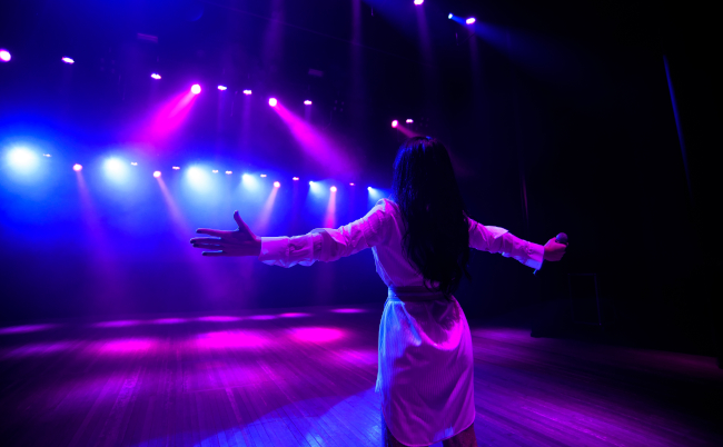 Unrecognizable,Singer,Standing,On,Stage,At,Microphone,,Back,View,,Neon