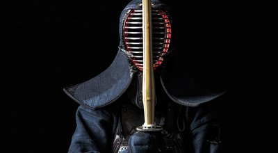 Japanese kendo fighter with with shinai on a black background