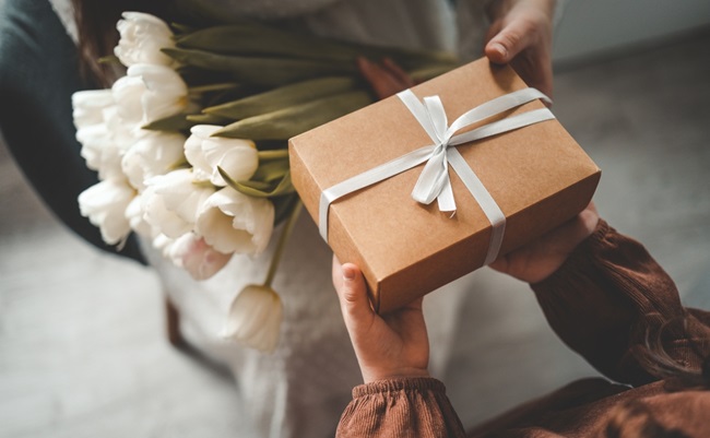 The,Child's,Hands,Hold,A,Beautiful,Gift,Box,With,A