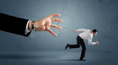 Business,Man,Running,Away,From,A,Huge,Hand,Concept,On