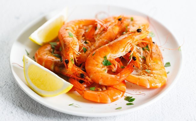 Steamed,Shrimps,With,Herbs,And,Sliced,Lemon,On,White,Plate.