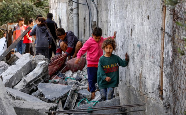 People,Gather,Near,A,Destroyed,Building,Following,An,Israeli,Air