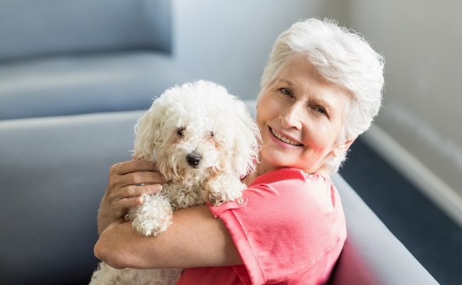 Senior,Woman,Holding,A,Dog,In,A,Retirement,Home