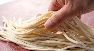 A,Man's,Hand,Holding,Fresh,Udon,Noodles.,Udon,Noodles,Before