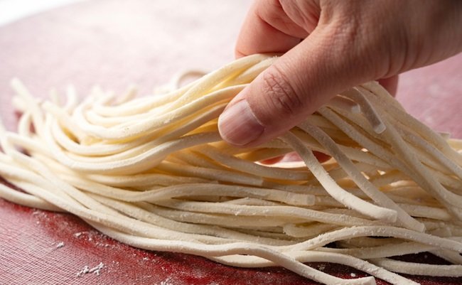 A,Man's,Hand,Holding,Fresh,Udon,Noodles.,Udon,Noodles,Before