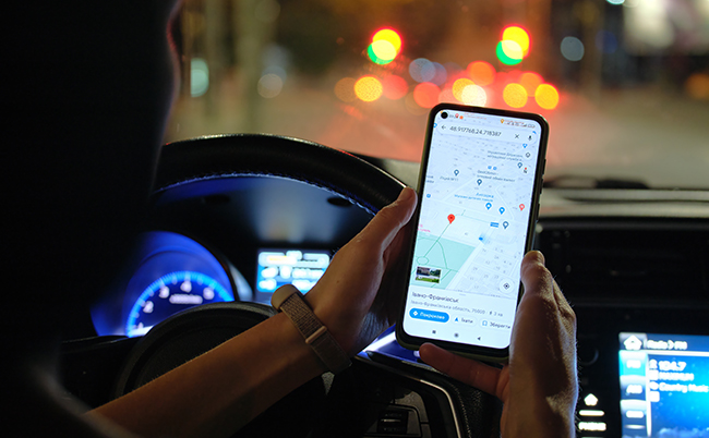 Close,Up,Of,Driver,Hands,Holding,Cellphone,With,Google,Maps