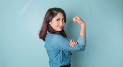Excited,Asian,Woman,Wearing,A,Blue,Shirt,Showing,Strong,Gesture