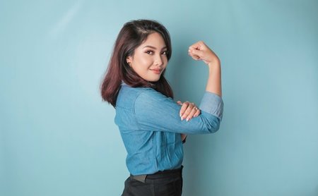 Excited,Asian,Woman,Wearing,A,Blue,Shirt,Showing,Strong,Gesture